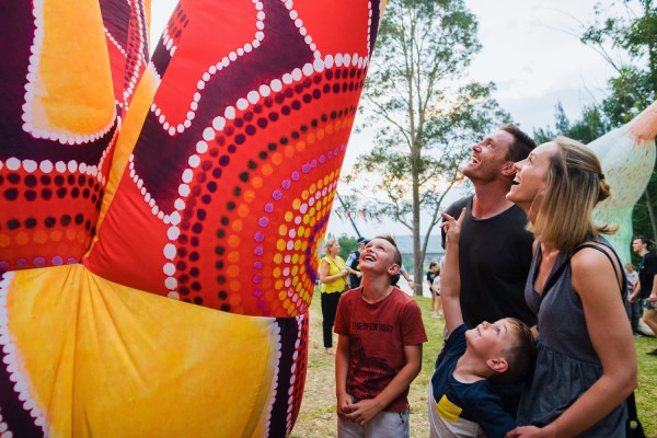 family group observing indigenous artwork display
